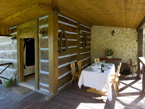 een tafel en stoelen op de veranda van een hut bij Holiday Home Bastrówka by Interhome in Chrosna