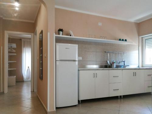 cocina con armarios blancos y nevera blanca en Apartment Laura-1 by Interhome, en Castellammare di Velia