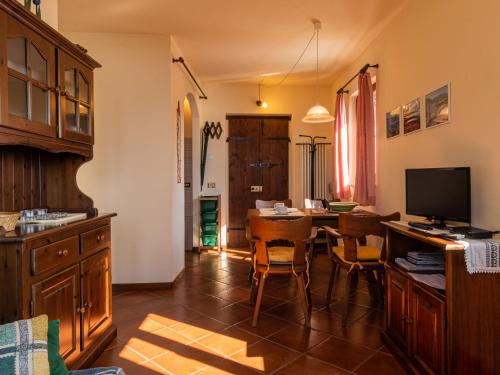 uma cozinha com uma mesa com cadeiras e uma televisão em Apartment Arte e Cucina-1 by Interhome em Gravedona
