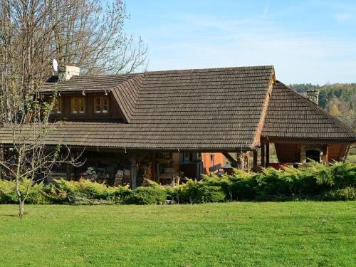 a house with a shingled roof in a yard at Holiday Home Borówna by Interhome in Lipnica Górna