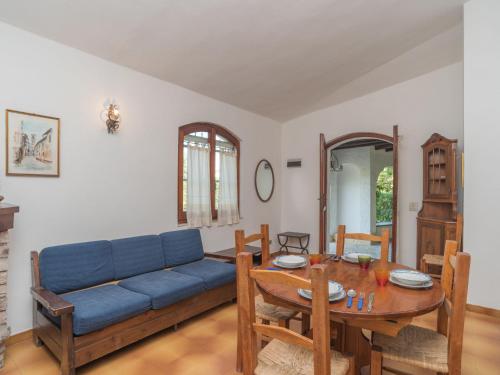 un soggiorno con divano blu e tavolo di Holiday Home Gigli - REI226 by Interhome a Costa Rei