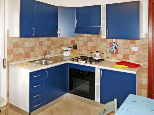 a kitchen with blue cabinets and a sink at Holiday Home Lia by Interhome in La Caletta