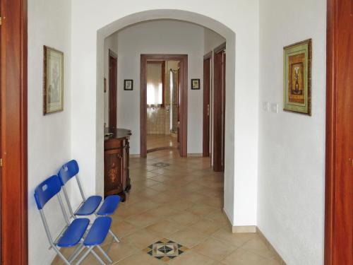 a hallway with two blue chairs and a desk at Holiday Home Lia by Interhome in La Caletta
