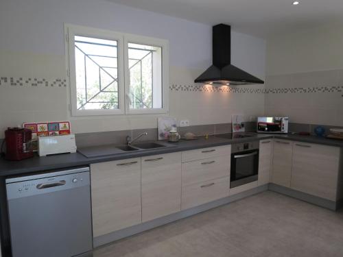 une cuisine avec des armoires blanches, un évier et une fenêtre dans l'établissement Holiday Home La Casita by Interhome, à Civrac-en-Médoc