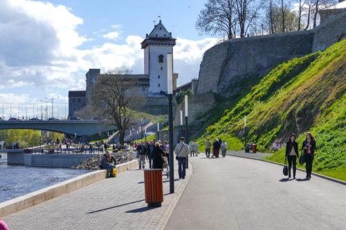 a group of people walking on a sidewalk next to a hill at Vanalinna Apartment in Narva