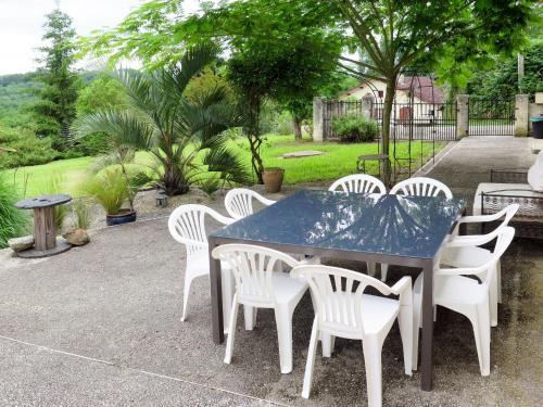 - une table bleue et des chaises blanches sur la terrasse dans l'établissement Holiday Home Aucéloun - NAS100 by Interhome, à Nassiet