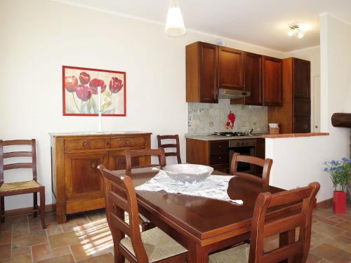 eine Küche mit einem Holztisch und Stühlen sowie ein Esszimmer in der Unterkunft Apartment La Corte Bricca - Bilo C by Interhome in Castana