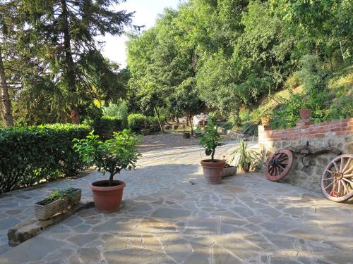 a patio with two potted plants and a stone wall at Holiday Home L'Orlo del Bosco by Interhome in Levane