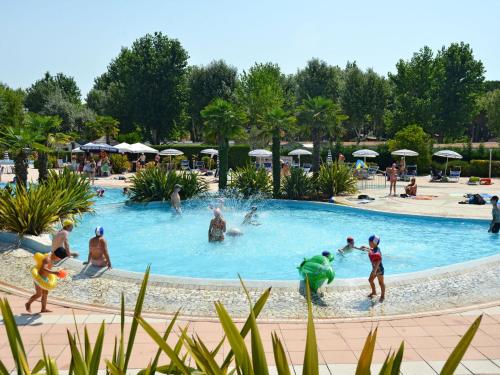 a group of people playing in a swimming pool at Holiday Home Camping Laguna Village by Interhome in Porto Falconera