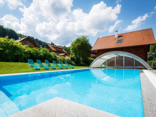 einen Pool mit Stühlen und ein Haus in der Unterkunft Holiday Home Sonnleiten-3 by Interhome in Schlierbach