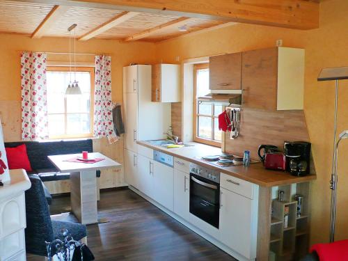 a kitchen with white cabinets and a table in a room at Chalet Weitsicht by Interhome in Lichtenhain