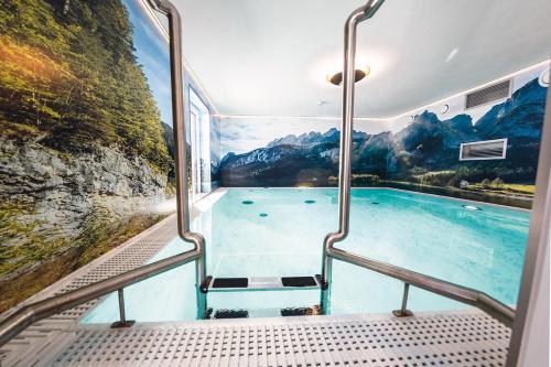 a swimming pool with a mural of a mountain at Wellness- und Familienoase Dachsteinresort in Russbach am Pass Gschütt