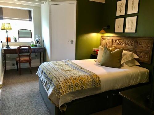 a bedroom with a bed with a desk and a window at The Bridge House in Bridport