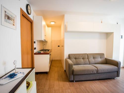 ein Wohnzimmer mit einem Sofa und einer Küche in der Unterkunft Apartment Albergo Diffuso - Cjasa de Pagnocca-1 by Interhome in Barcis
