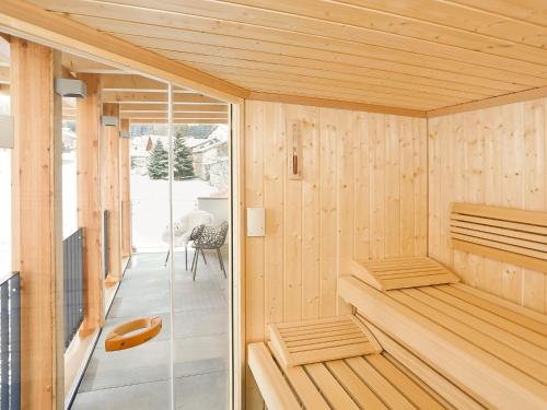 a sauna with wooden walls and a glass door at Holiday Home von Capeller by Interhome in Parpan