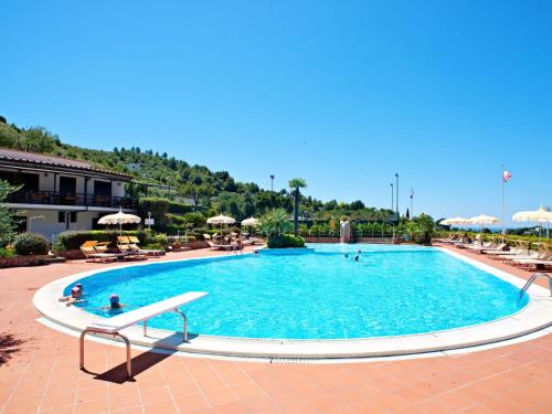 a large swimming pool in a resort with people in it at Apartment Costa di Kair ed Din-6 by Interhome in Sperlonga