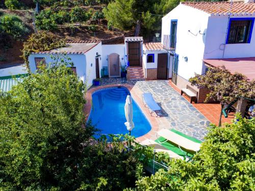 a villa with a swimming pool in front of a house at Holiday Home La Cordobilla - AMU172 by Interhome in Almuñécar