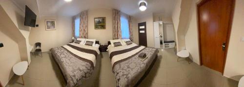 two beds in a small room with a room with a bathroom at Apartamenty Mieszkaniowe Kadrema in Rybczewice