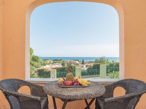 un tavolo con un cesto di frutta sul balcone di Holiday Home Case Greche Basse - REI235 by Interhome a Costa Rei