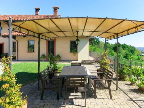 patio ze stołem i krzesłami pod pergolą w obiekcie Holiday Home General Massena - NAZ112 by Interhome w mieście Bene Vagienna
