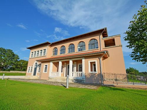 a large house with a green lawn in front of it at Villa Old School House by Interhome in Bašići