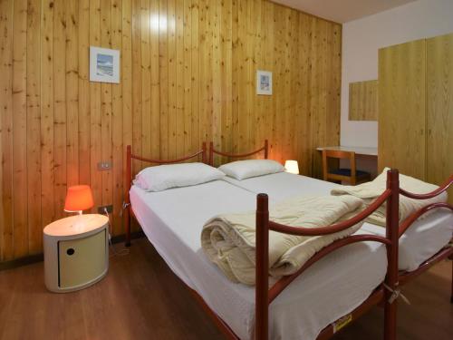 a bedroom with a large bed with wooden walls at Holiday Home Villa Martinelli-3 by Interhome in Vesta