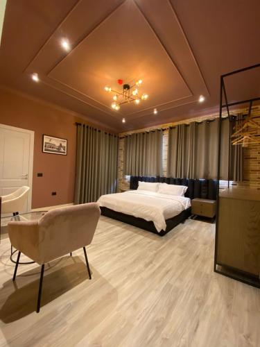 a large bedroom with a bed and a chair at Ardenica Boutique Hotel in Lushnjë