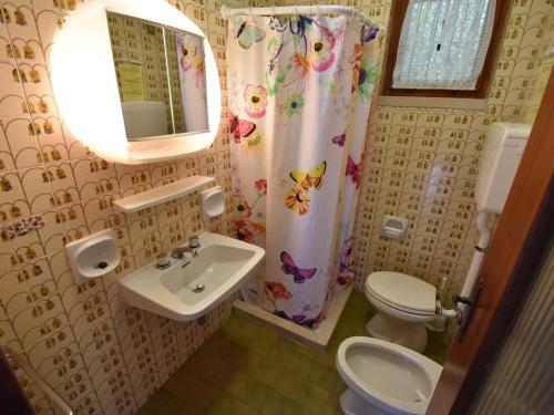 a bathroom with a sink and a toilet and a mirror at Holiday Home Villa Martinelli-3 by Interhome in Vesta