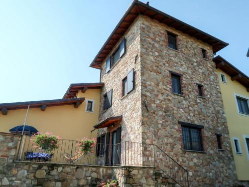 Holiday Home La Corte Bricca - Trilo Torretta by Interhome في Castana: مبنى حجري كبير امامه سياج