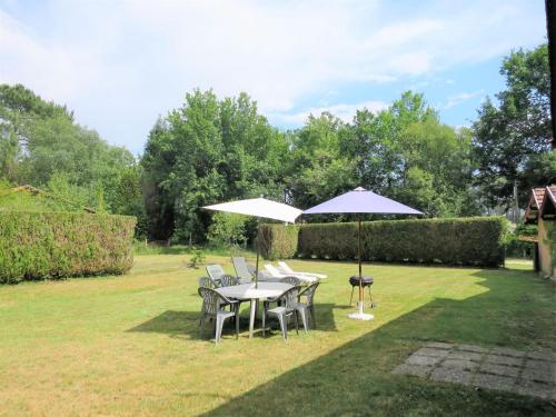 a table and chairs with umbrellas in a yard at Holiday Home Vignas by Interhome in Le Porge