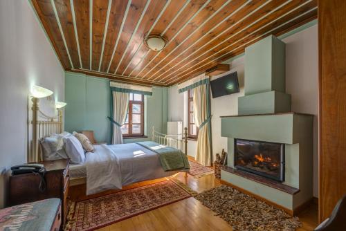 ein Schlafzimmer mit einem Bett und einem Kamin in der Unterkunft Arxontiko Krana in Asprangeloi