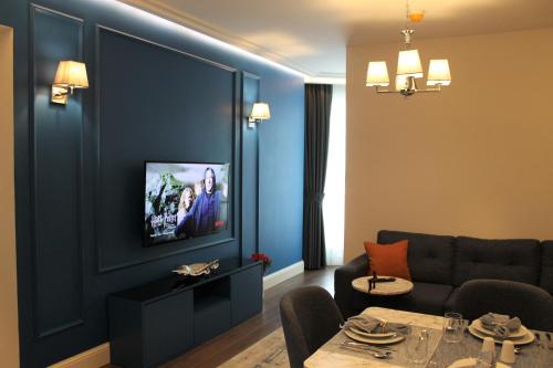 a living room with a couch and a tv on a wall at Garlon Residence in Istanbul