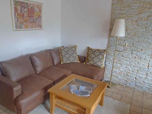 a living room with a brown couch and a table at Holiday Home Adda by Interhome in Neßmersiel