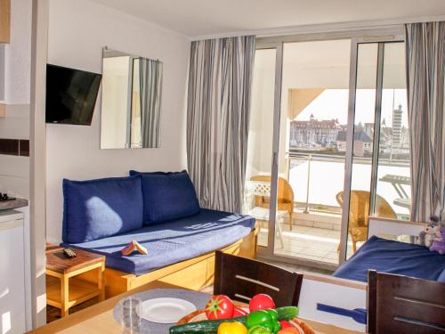 un salon avec un canapé bleu et un balcon dans l'établissement Apartment Le Beach by Interhome, à Trouville-sur-Mer