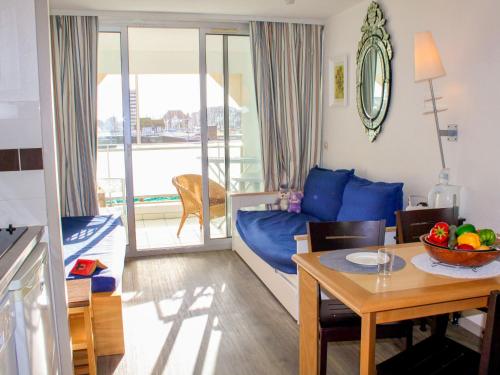 un salon avec un canapé bleu et une table dans l'établissement Apartment Le Beach by Interhome, à Trouville-sur-Mer