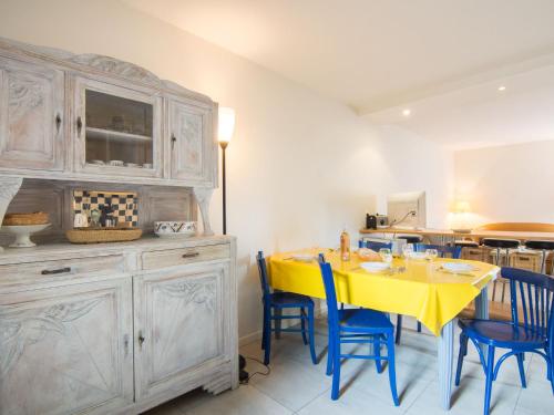 une salle à manger avec une table jaune et des chaises bleues dans l'établissement Holiday Home Petit Acacia by Interhome, à Dinard