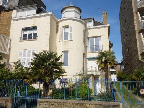 un vecchio edificio con palme di fronte di Apartment Le Beauvoir Rose by Interhome a Dinard