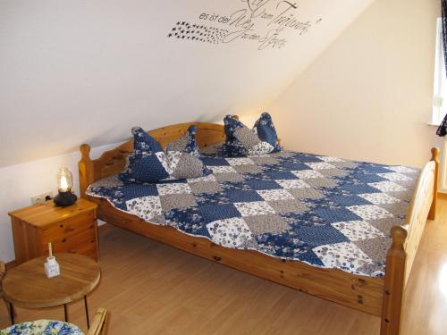um quarto com uma cama com uma colcha azul e branca em Holiday Home Entenkoje by Interhome em Dornum