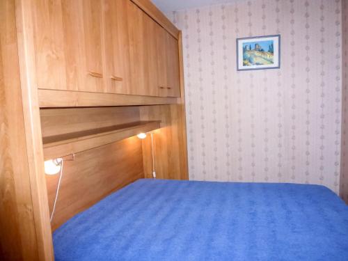 - une petite chambre avec un lit et une armoire en bois dans l'établissement Apartment Camargue Village-2 by Interhome, au Grau-du-Roi