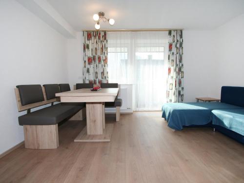 a room with a table and chairs and a bed at Apartment Alpenrose-2 by Interhome in See