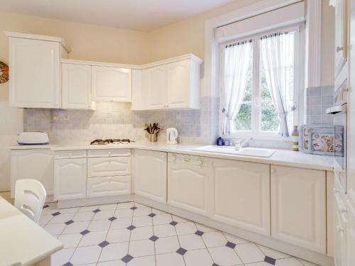 eine Küche mit weißen Schränken und Fliesenboden in der Unterkunft Apartment L'écluse-1 by Interhome in Dinard