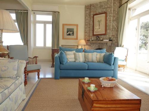 un salon avec un canapé bleu et une table dans l'établissement Villa La Source by Interhome, à Dinard