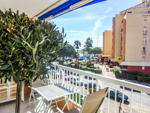 a balcony with a table and chairs and a street at Apartment Le Méditerranée-2 by Interhome in Fréjus