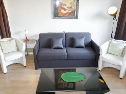 un salon avec un canapé et deux chaises dans l'établissement Apartment Le Corsaire-5 by Interhome, à Cannes