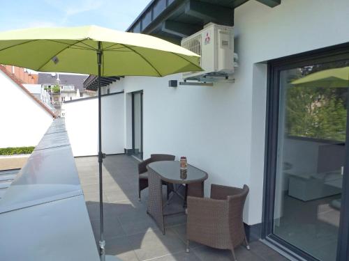 a patio with a table and a green umbrella at Apartment Brake by Interhome in Offenburg