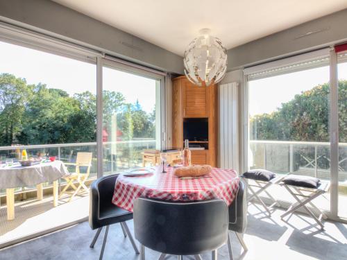 une salle à manger avec une table, des chaises et des fenêtres dans l'établissement Apartment Le Parc de La Ronceray-1 by Interhome, à Dinard