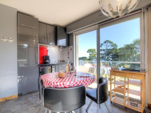 een keuken met een tafel en stoelen en een groot raam bij Apartment Le Parc de La Ronceray-1 by Interhome in Dinard