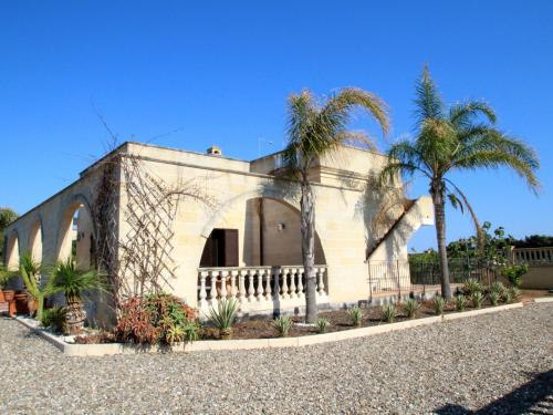un bâtiment avec des palmiers en face de celui-ci dans l'établissement Villa Alberto by Interhome, à Marina di Lizzano