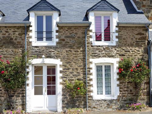 une maison en pierre avec des fenêtres blanches et des fleurs dans l'établissement Apartment Le Petit Robinson-1 by Interhome, à La Richardais