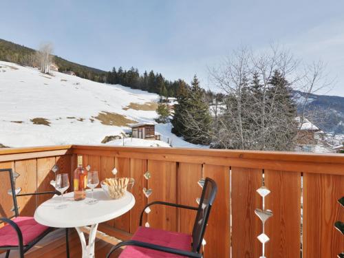 a balcony with a table and chairs and snow covered mountains at Apartment Luca by Interhome in Ortisei